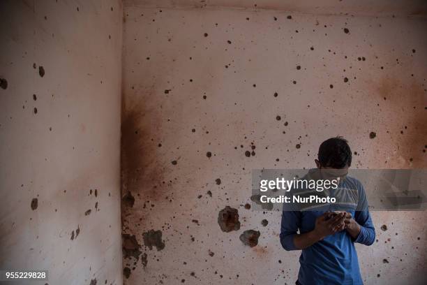 Kashmiri men inspect a house, damaged during a gun fight, where suspected rebels were holed up Saturday, May 5 in Srinagar, Indian-controlled...
