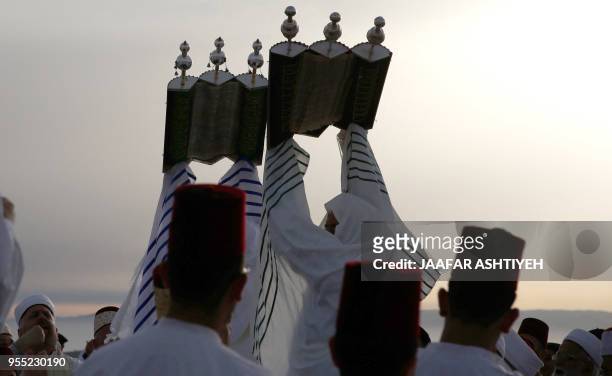 Samaritan worshippers raise a Torah scroll during a Passover ceremony at Mount Gerizim near the northern West Bank city of Nablus, on May 6 , 2018....
