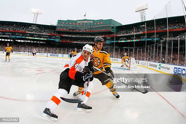 Ian Laperriere of the Philadelphia Flyers against Andrew Ference of the Boston Bruins during the 2010 Bridgestone Winter Classic at Fenway Park on...