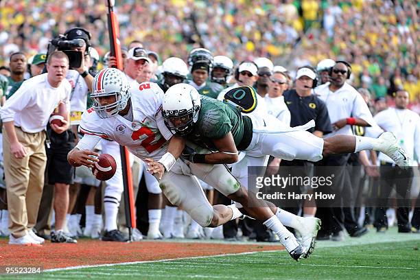 Quarterback Terrelle Pryor of the Ohio State Buckeyes loses the ball as he is hit by an Oregon Ducks defender during the 96th Rose Bowl game on...