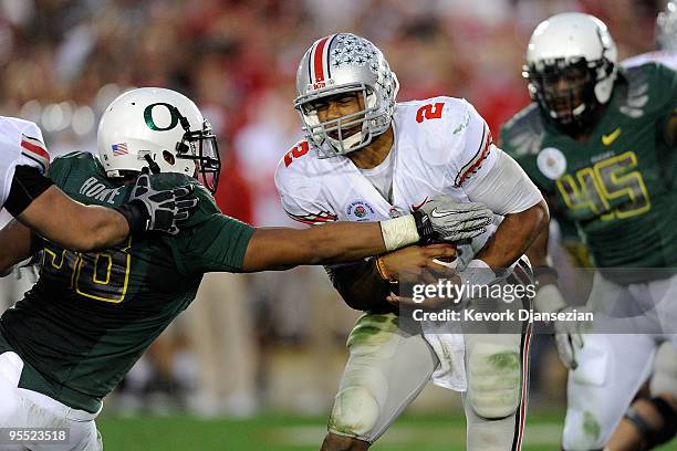 Quarterback Terrelle Pryor of the Ohio State Buckeyes runs with the ball against Kenny Rowe of the Oregon Ducks during the 96th Rose Bowl game on...