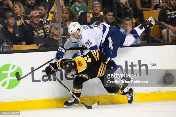 Torey Krug of the Boston Bruins checks Anthony Cirelli of the Tampa Bay Lightning in Game Four of the Eastern Conference Second Round during the 2018...