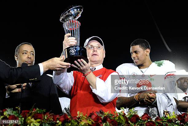 Head coach Jim Tressel of the Ohio State Buckeyes celebrates with the Rose Bowl championship trophy as quarterback Terrelle Pryor looks on after the...