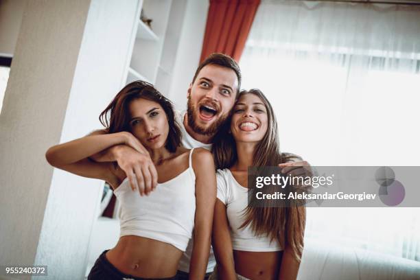 group of embraced friends make silly faces and posing at home - sofa bed stock pictures, royalty-free photos & images