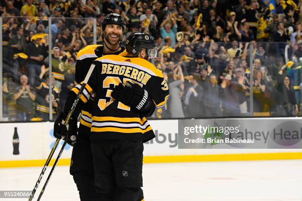 Zdeno Chara of the Boston Bruins hugs teammate Patrice Bergeron after a goal against the Tampa Bay Lightning in Game Four of the Eastern Conference...