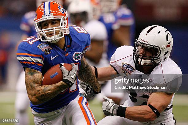 Aaron Hernandez of the Florida Gators avoids a tackle by J.K. Schaffer of the Cincinnati Bearcats during the Allstate Sugar Bowl at the Louisana...