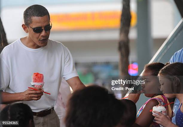 President Barack Obama enjoys a 'Snowbama' with his daughter Sasha and Family friends at Island Snow on January 1, 2010 in Kailua, Hawaii. Obama and...