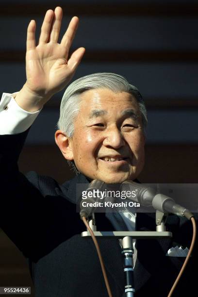 Emperor Akihito waves to the well-wishers celebrating the New Year at the Imperial Palace on January 2, 2010 in Tokyo, Japan.
