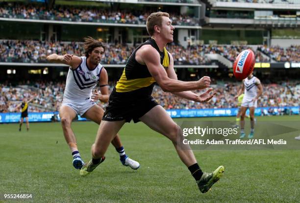 Jacob Townsend of the Tigers handpasses the ball during the 2018 AFL round seven match between the Richmond Tigers and the Fremantle Dockers at the...