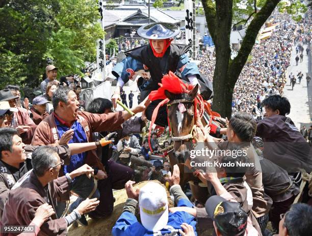 Young man rides a horse over a 2-meter-high clay wall in a festival at Tado Taisha, a Shinto shrine in Kuwana in Mie Prefecture, central Japan, on...