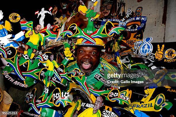 Alfred 'Lux' Baloyi, designer of the famous Makarapa football 2010 helmet poses alongside his different designs on January 1, 2010 in Germiston,...