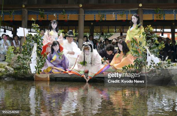 Shiho Sakashita , an office worker in Kyoto clad in a 12-layer traditional Japanese kimono, purifies herself at Kamigamo Jinja, a Shinto shrine in...