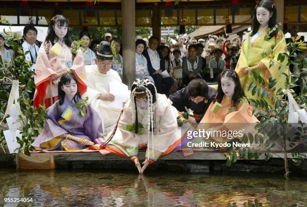 Shiho Sakashita , an office worker in Kyoto clad in a 12-layer traditional Japanese kimono, purifies herself at Kamigamo Jinja, a Shinto shrine in...