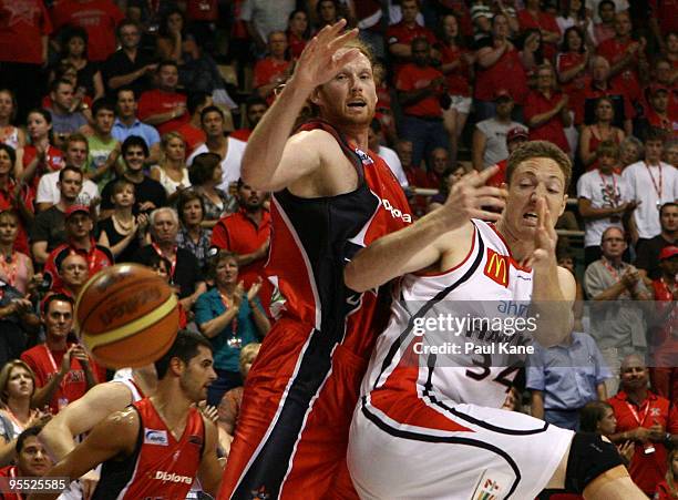 Luke Schenscher of the Wildcats and Tim Behrendorff of the Hawks contest a rebound during the round 14 NBL match between the Perth Wildcats and the...