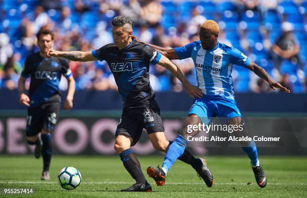 Brown Aide Ideye of Malaga competes for the ball with Daniel Torres of Deportivo Alaves during the La Liga match between Malaga and Deportivo Alaves...