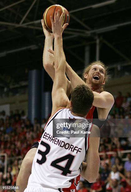 Luke Schenscher of the Wildcats lays up over Tim Behrendorff of the Hawks during the round 14 NBL match between the Perth Wildcats and the Wollongong...