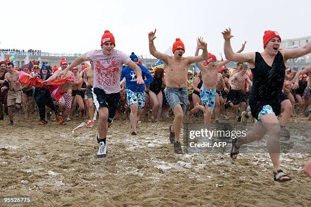 People run from the beach into the North Sea during a traditional New Year's dive in Oostende on January 2, 2010. AFP PHOTO/BELGA/KURT DESPLENTER