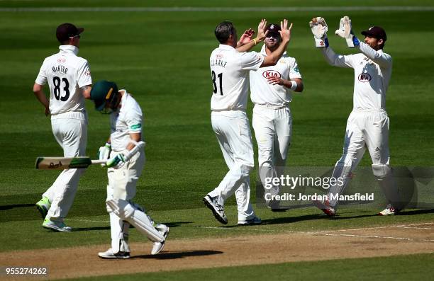 Rikki Clarke of Surrey celebrates with his teammates after dismissing Daryl Mitchell of Worcestershire during day three of the Specsavers County...