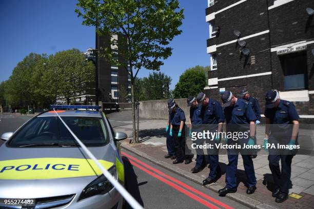 Police officers comb the cordoned area in Camberwell New Road, Southwark, south London, as 17-year-old Rhyhiem Ainsworth Barton was shot dead at...