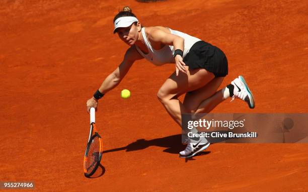 Simona Halep of Romania stretches to play a forehand against Ekaterina Makarova of Russia in their first round match during day two of the Mutua...