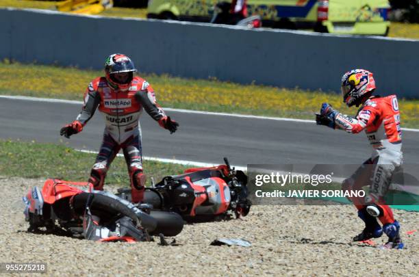 Ducati Team's Italian rider Andrea Dovizioso and Ducati Team's Spanish rider Jorge Lorenzo stand next to their bikes after falling down during the...