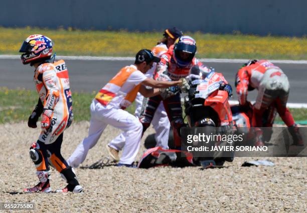 Repsol Honda Team's Spanish rider Dani Pedrosa walks past Ducati Team's Italian rider Andrea Dovizioso and Ducati Team's Spanish rider Jorge Lorenzo...