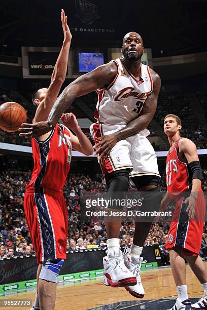Shaquille O'Neal of the Cleveland Cavaliers passes against Yi Jianlian of the New Jersey Nets during the game on January 2, 2010 at the Izod Center...