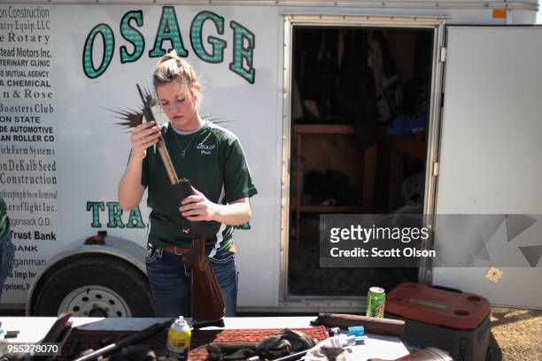 Senior Mady Dohlman of the Osage High School trap team cleans her shotgun following a match at the Mitchell County Trap Range on May 5, 2018 in...