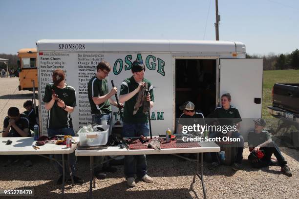 Members of the Osage High School trap team clean guns following a match at the Mitchell County Trap Range on May 5, 2018 in Osage, Iowa. The Osage...