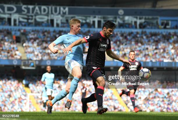 Christopher Schindler of Huddersfield Town is challenged by Kevin De Bruyne of Manchester City during the Premier League match between Manchester...