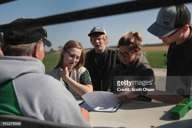 Members of the Osage High School trap team check their scores during a match at the Mitchell County Trap Range on May 5, 2018 in Osage, Iowa. The...