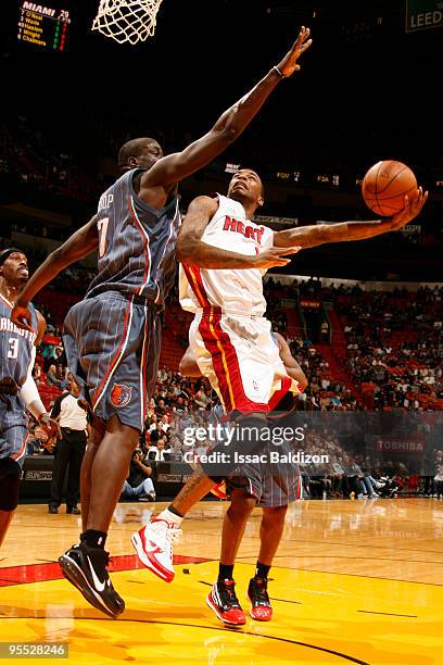 Dorell Wright of the Miami Heat shoots against DeSagana Diop of the Charlotte Bobcats on January 2, 2010 at American Airlines Arena in Miami,...