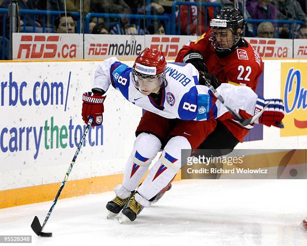Alexander Burmistrov of Team Russia skates with the puck while being chased by Nino Niederreiter of Team Switzerland during the 2010 IIHF World...