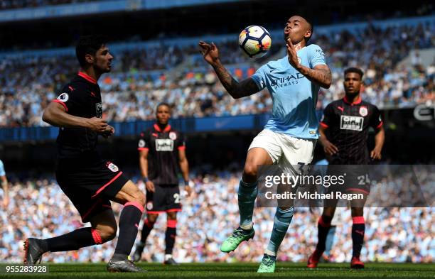 Gabriel Jesus of Manchester City controls the ball while under pressure from Christopher Schindler of Huddersfield Town during the Premier League...