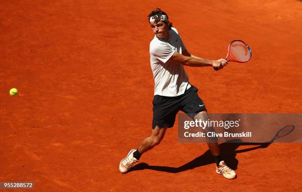 Taylor Fritz of the United States plays a backhand against Nicolas Kicker of Argentina in their first round match during day two of the Mutua Madrid...