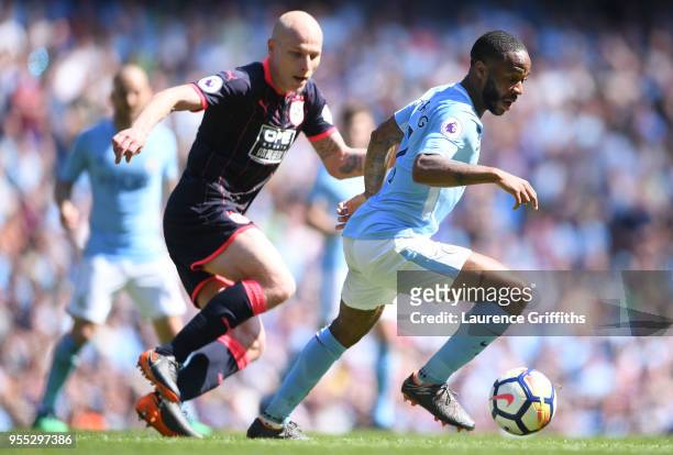 Raheem Sterling of Manchester City is challenged by Aaron Mooy of Huddersfield Town during the Premier League match between Manchester City and...