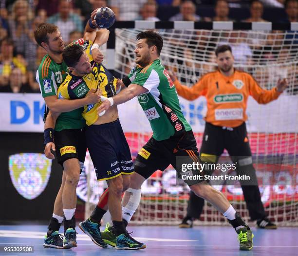 Ilija Brozovi and Evgeni Pevnov of Hannover challenge Alexander Petersson of Rhein-Neckar during the final of the DKB Handball Bundesliga Final Four...