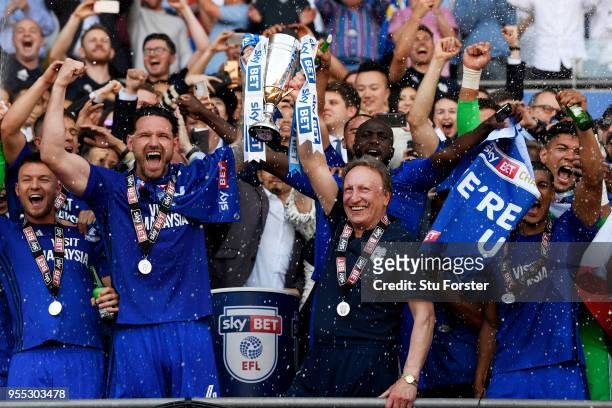 Sean Morrison of Cardiff City lifts the trophy with Neil Warnock, Manager of Cardiff City as they celebrate gaining promotion back to the premier...