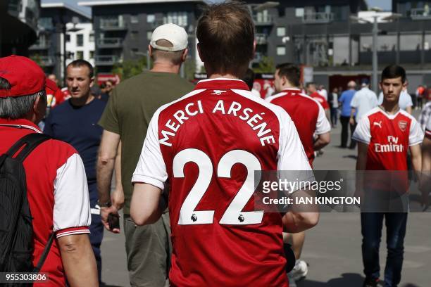 An Arsenal supporter wears a shirt with "Merci Arsene" on the back for Arsenal's departing manager ahead of the English Premier League football match...