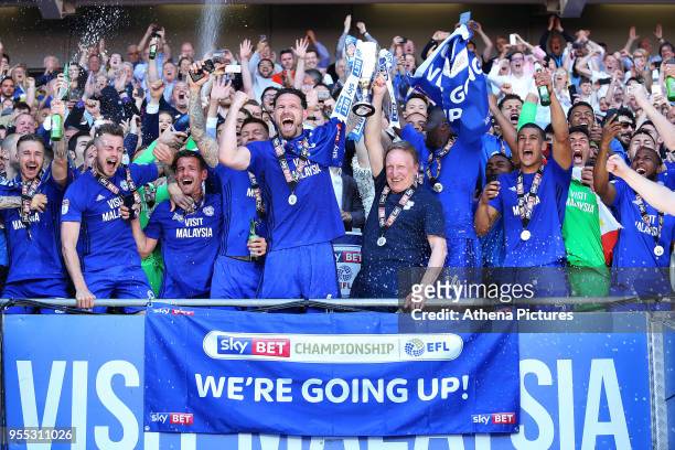 Sean Morrison of Cardiff City and Cardiff City manager Neil Warnock lift the trophy after being automatically promoted to the Premier League after...