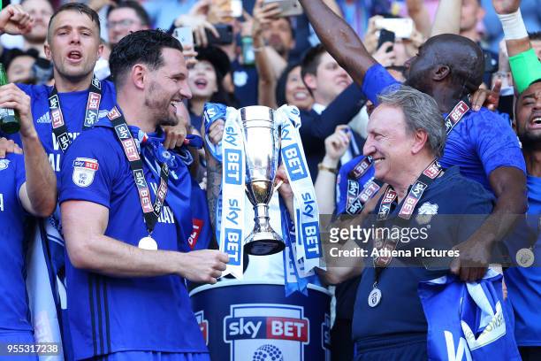 Sean Morrison of Cardiff City and Cardiff City manager Neil Warnock laugh as they lift the trophy after being automatically promoted to the Premier...
