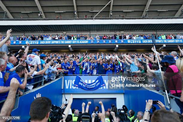 Sean Morrison of Cardiff City lifts the trophy as Cardiff City manager Neil Warnock and Cardiff celebrate after being automatically promoted to the...