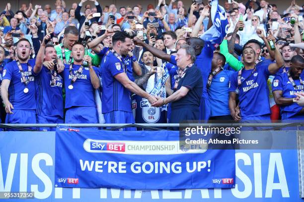 Sean Morrison of Cardiff City and Cardiff City manager Neil Warnock shake hands as they lift the trophy after being automatically promoted to the...