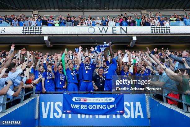 Sean Morrison of Cardiff City and Sol Bamba lifts the trophy after being automatically promoted to the Premier League after the final whistle of the...