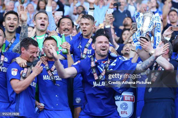 Sean Morrison of Cardiff City laughs as Cardiff City manager Neil Warnock lifts the trophy after being automatically promoted to the Premier League...