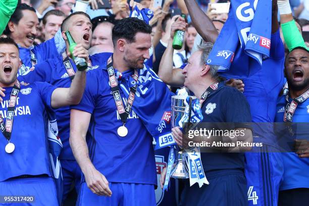 Sean Morrison of Cardiff City and Cardiff City manager Neil Warnock laugh as they lift the trophy after being automatically promoted to the Premier...