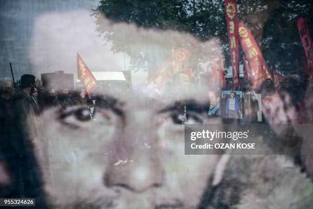 Turkish leftist activists are seen through a portrait of late Turkish student leader, and political activist Deniz Gezmis on May 6, 2018 at...