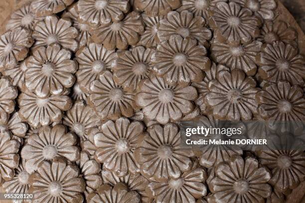 Tas de fleurs décoratives de terre qui seront collées sur des pots, New Delhi, Inde.