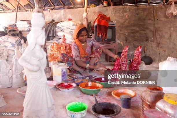 Les femmes et les enfants travaillent à la peinture des icones religieuses, New Delhi, Inde. Les maigres revenus de la vente feront survivre la...
