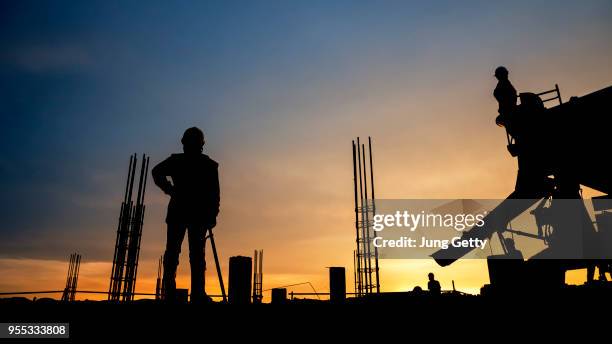 silhouette construction worker concrete pouring during commercial concreting floors of building in construction site and civil engineer inspection work - construction site and silhouette stock pictures, royalty-free photos & images